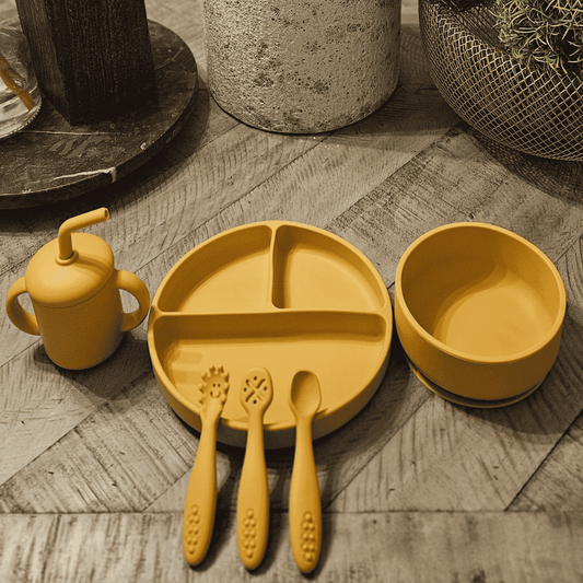 Yellow Silicone children's tableware set on a wooden floor