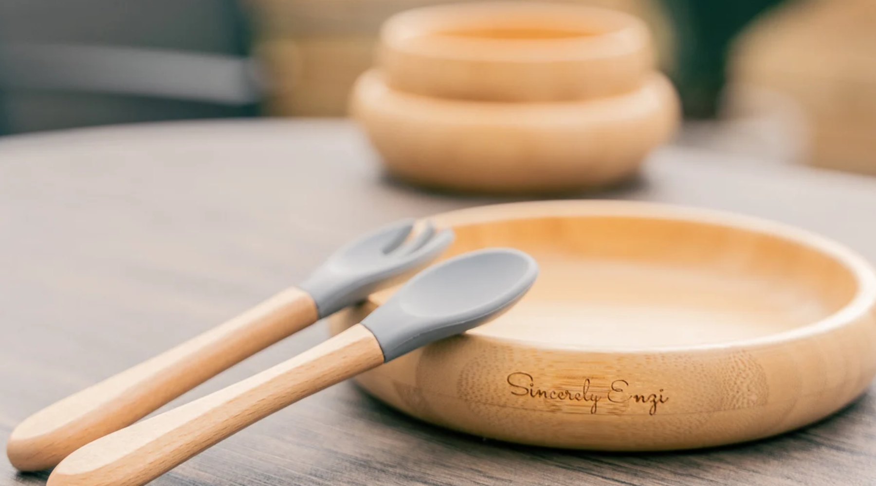 Wooden bowl and utensils with 'Sincerely Engi' engraving on a wooden surface.