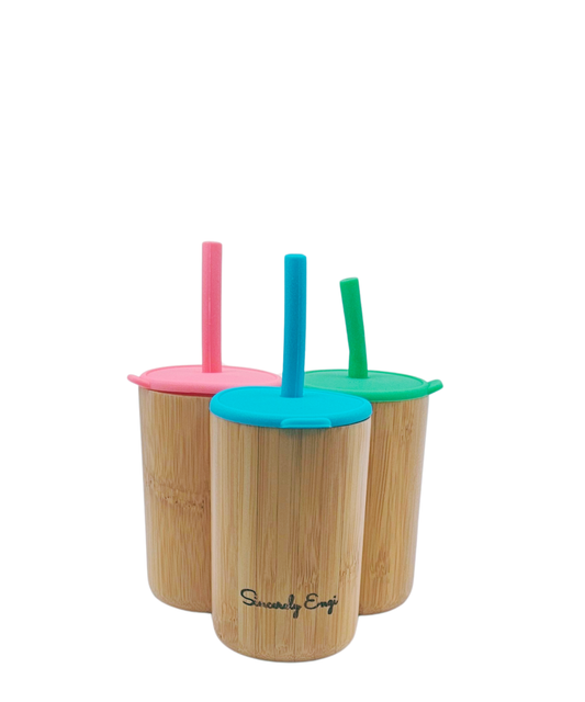 Three bamboo cups with colorful lids and straws on a white background